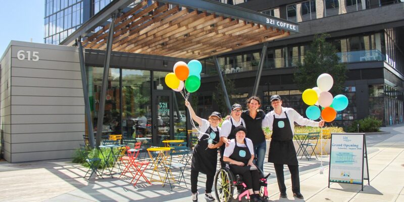 321 Coffee employees standing outside celebrating the grand opening of one of their Downtown Raleigh location
