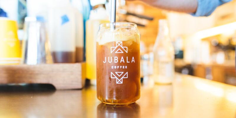 Barista stirring an iced coffee drink at Jubala Coffee